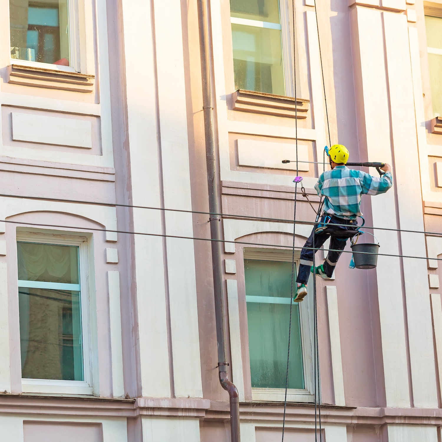 Man cleaning windows and wall on old city bulding